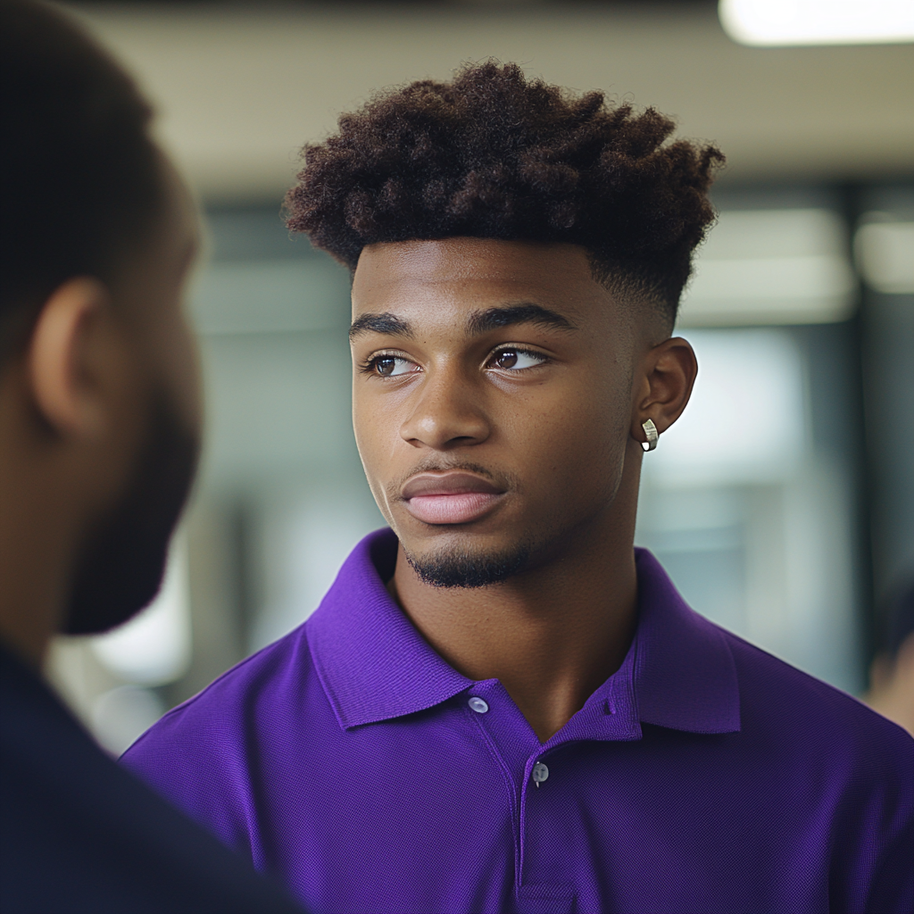 Young black student with stud earring talking to professor.